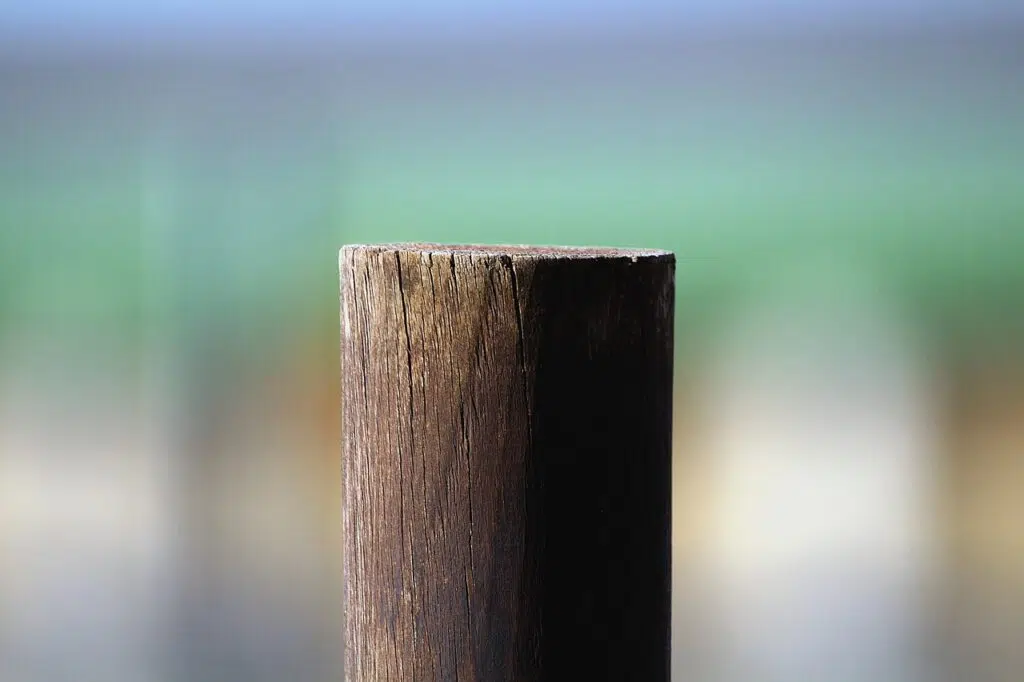 C'est une photo d'un poteau en bois avec un arrière-plan flou.
